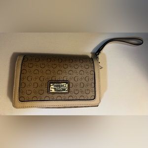 Guess brand tan clutch, with wrist strap, zipper pocket, 6 card slots,